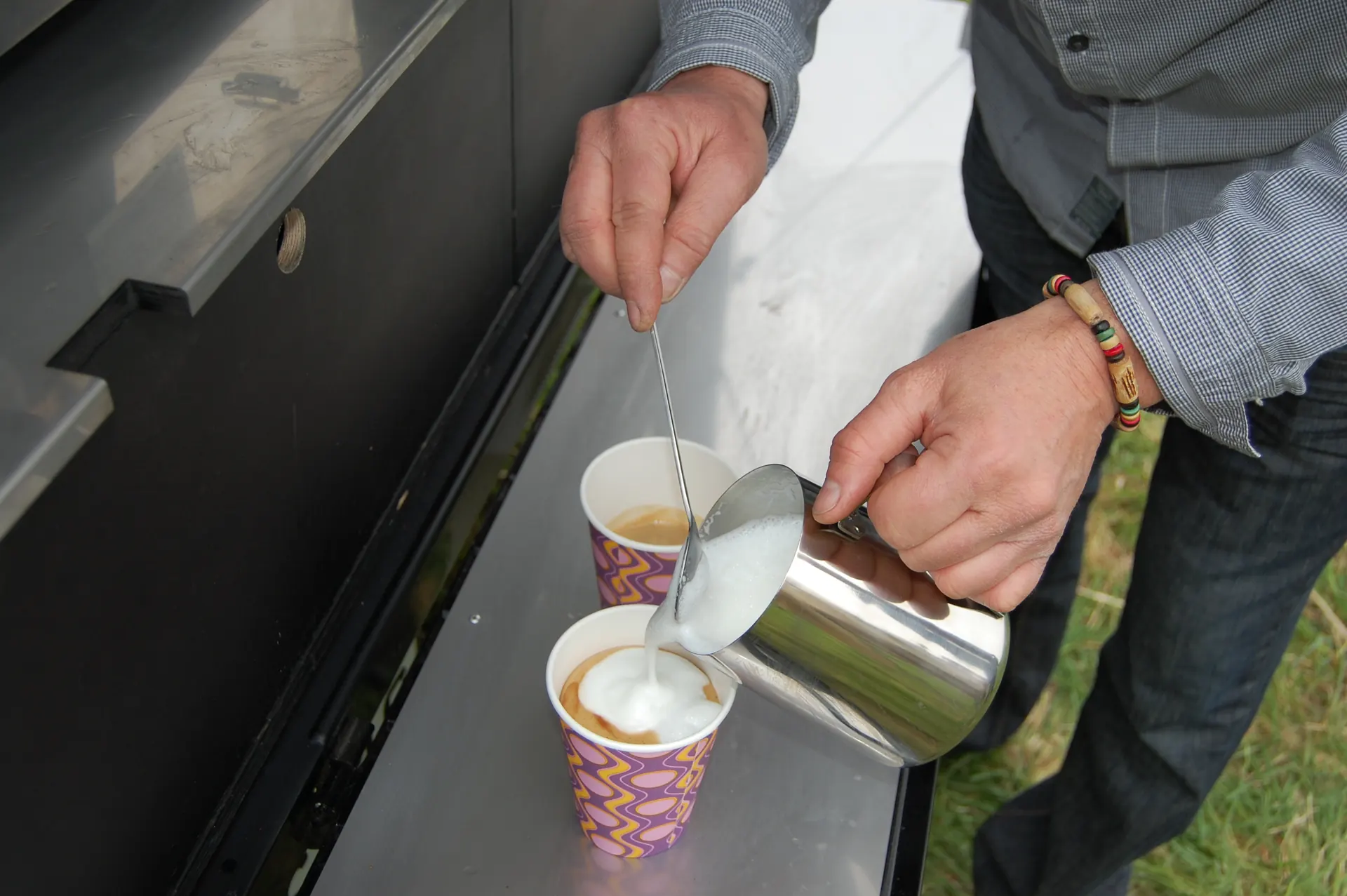 Milchschaum wird in einen Becher gegossen